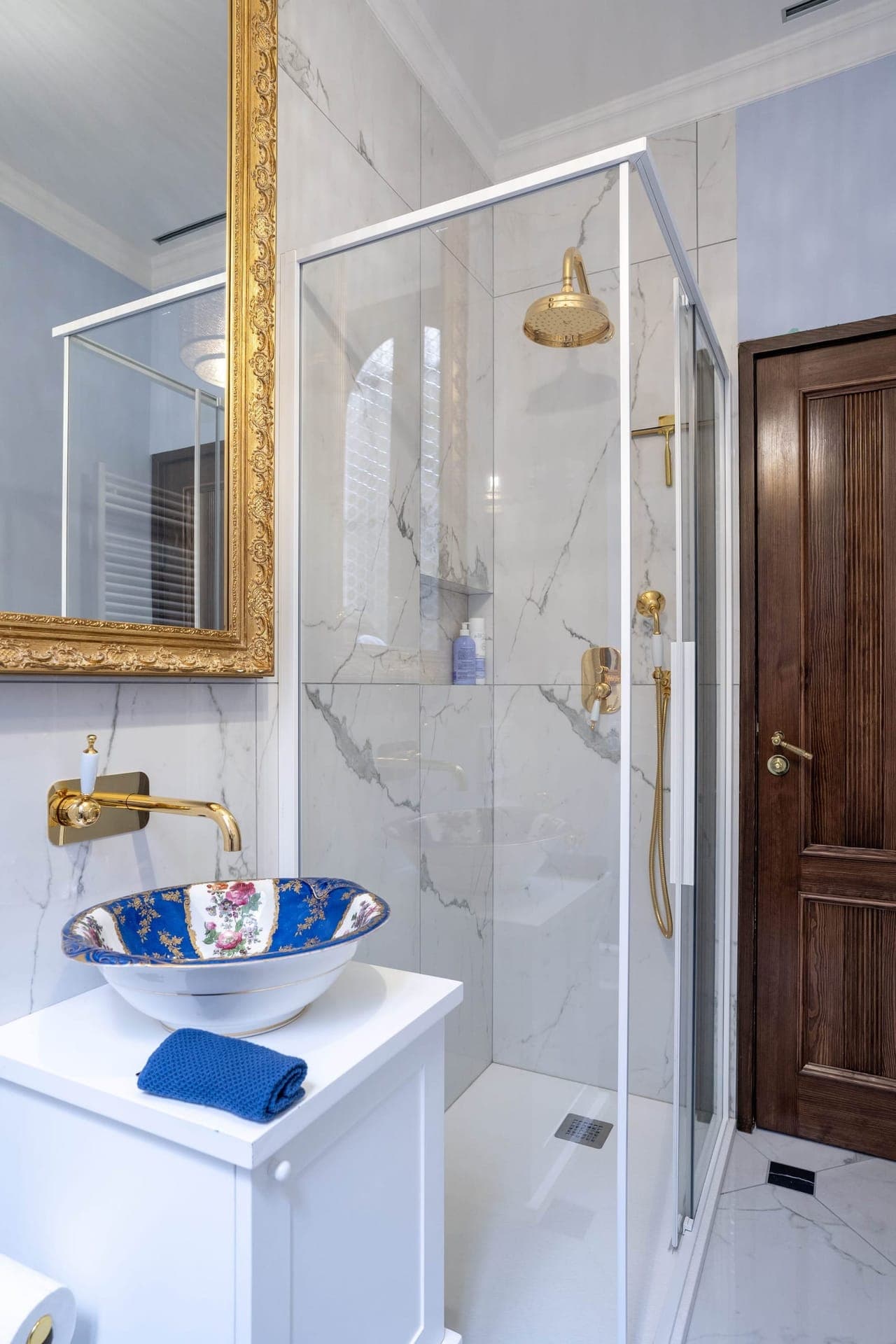 Marble shower room with gold rain head and hand-painted floral basin