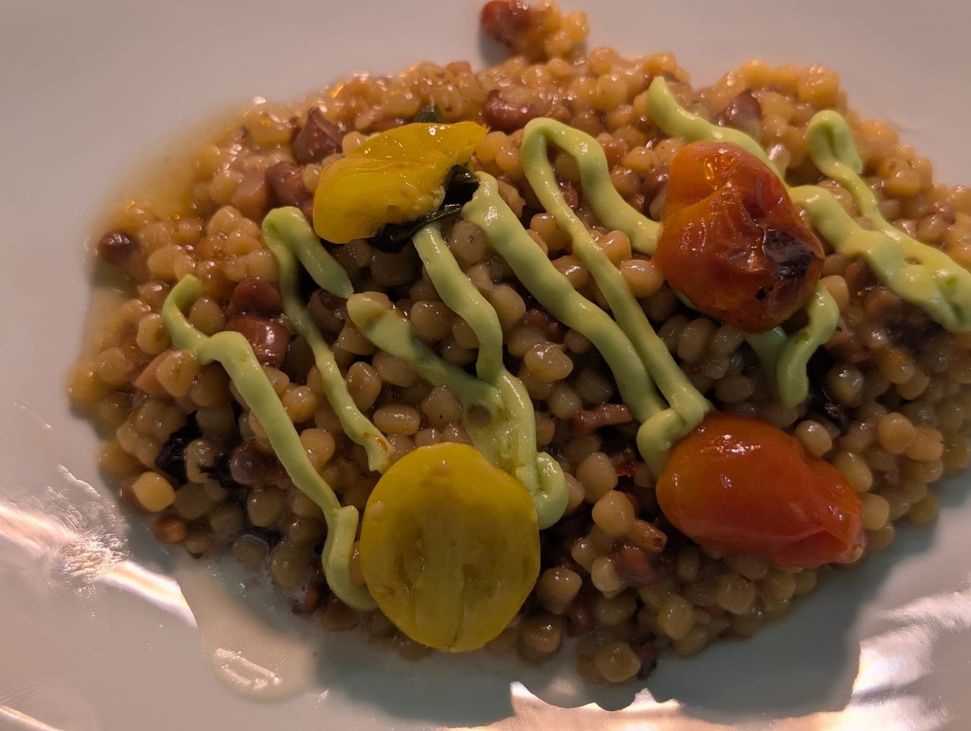 Fregola with confit cherry tomatoes and herb sauce