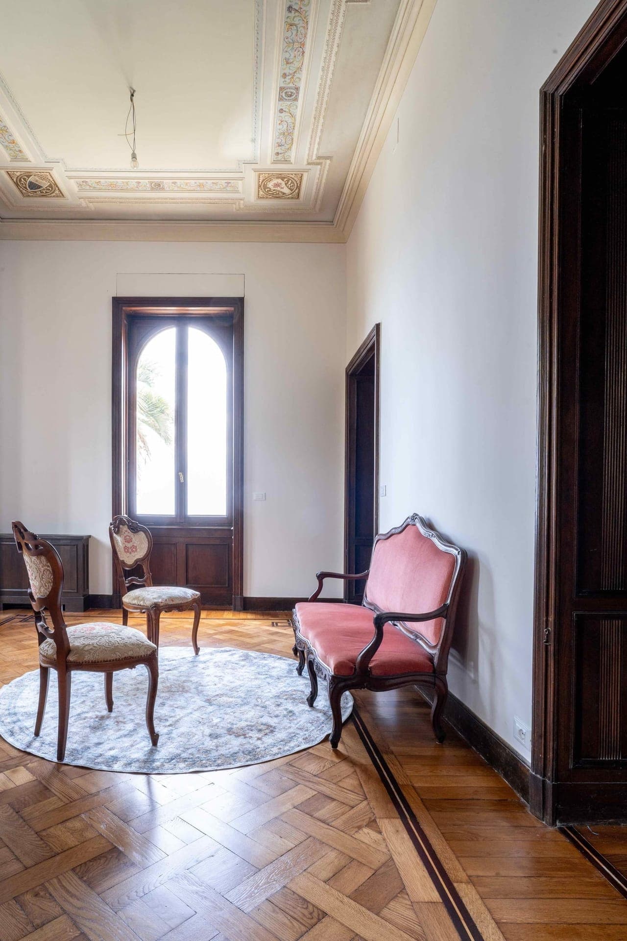 Sitting room with hand-painted frescoed ceiling and antique armchairs